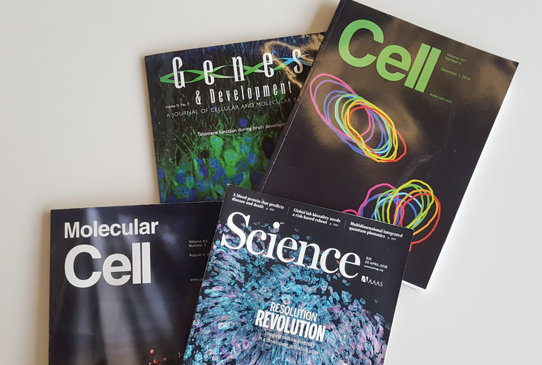 Several science magazines (Cell, Molecular Cell, Science, Genes & Development) displayed.